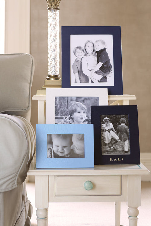 Jubilee landscape photograph frame collection displayed on a side table with a lamp.