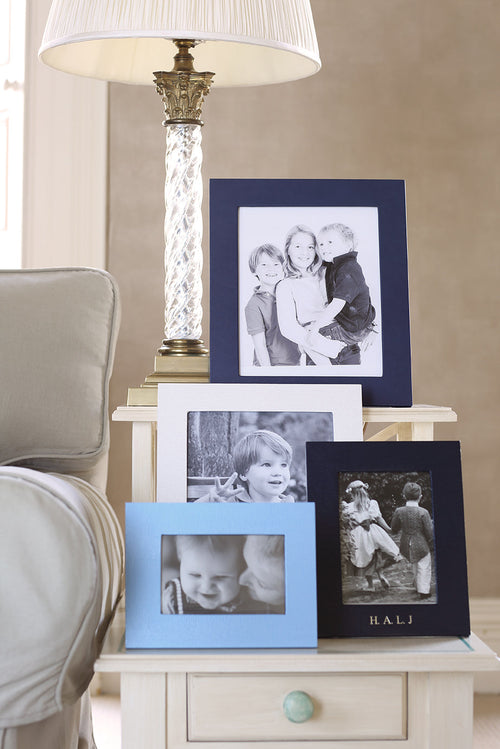 Chelsea Landscape Leather Photo Frame 7x5 displayed among other photo frames on a side table.